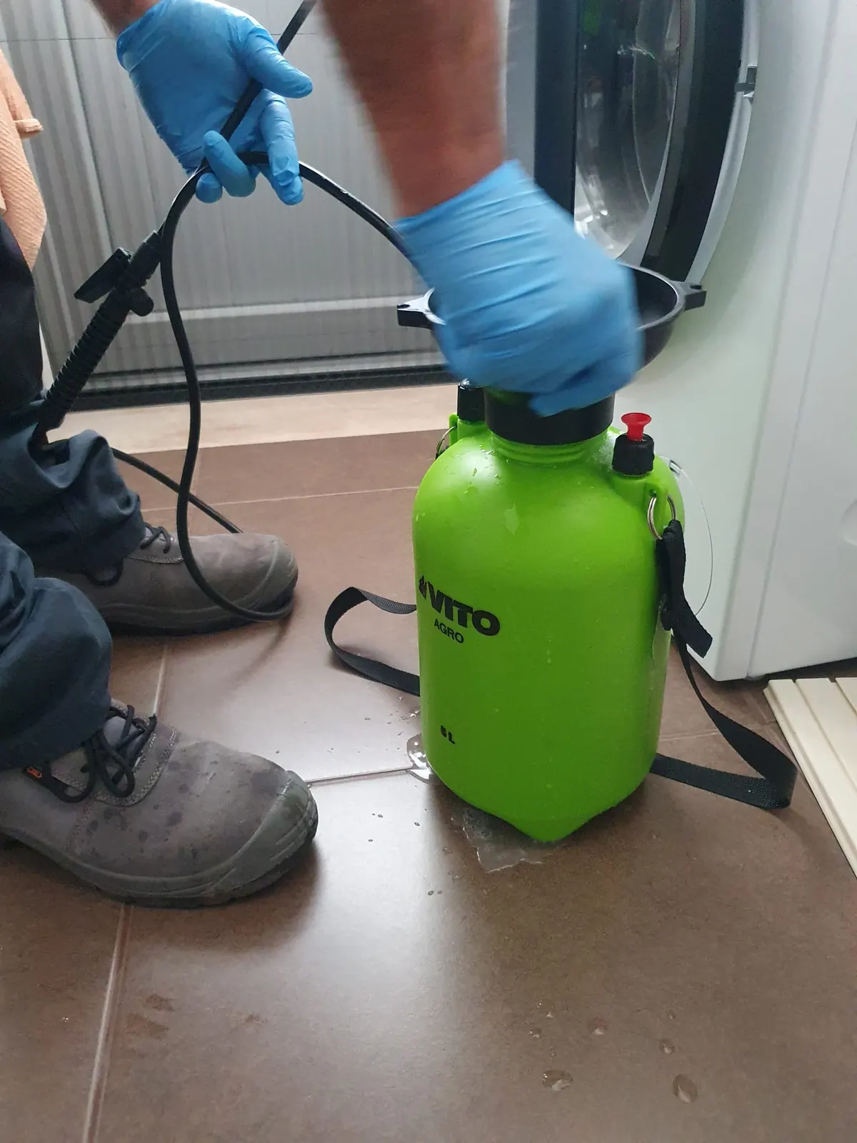 Técnico com luvas a preparar um pulverizador